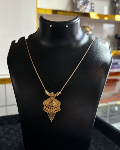 Gold kanthi with a fan-shaped pendant, on a display bust